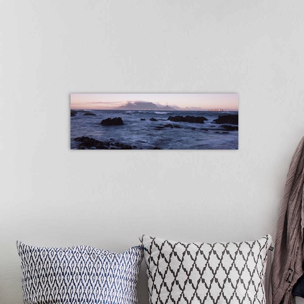 A bohemian room featuring Rocks in the sea with Table Mountain in the background, Bloubergstrand, Table Mountain, Cape Town...
