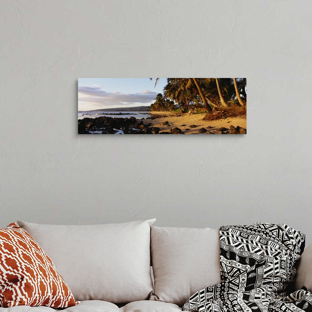 A bohemian room featuring This decorative wall art is a panoramic photograph of sunset on a tropical beach covered with vol...
