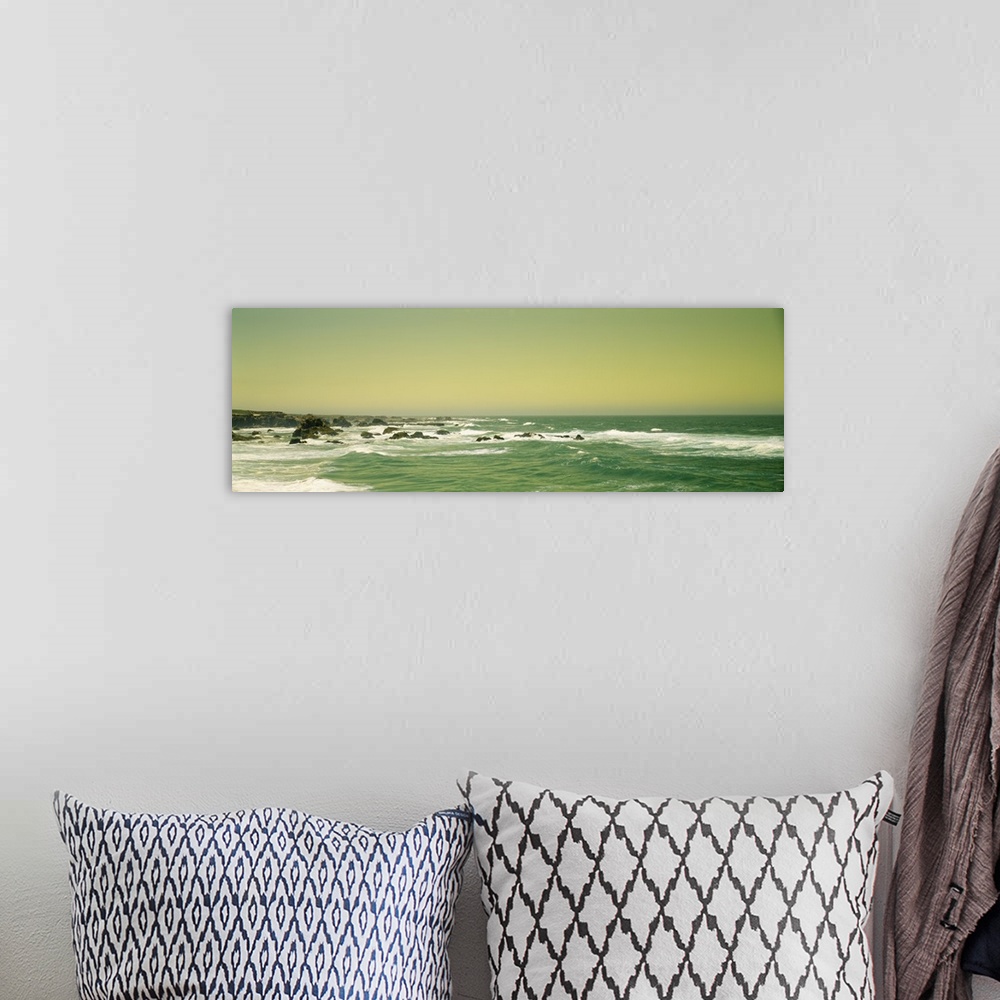 A bohemian room featuring Panoramic photograph of rocky shoreline.