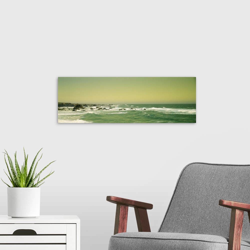 A modern room featuring Panoramic photograph of rocky shoreline.