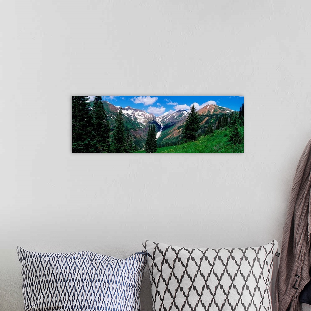 A bohemian room featuring This panoramic photograph taken from the side of a mountain looks across a valley to the snowcapp...