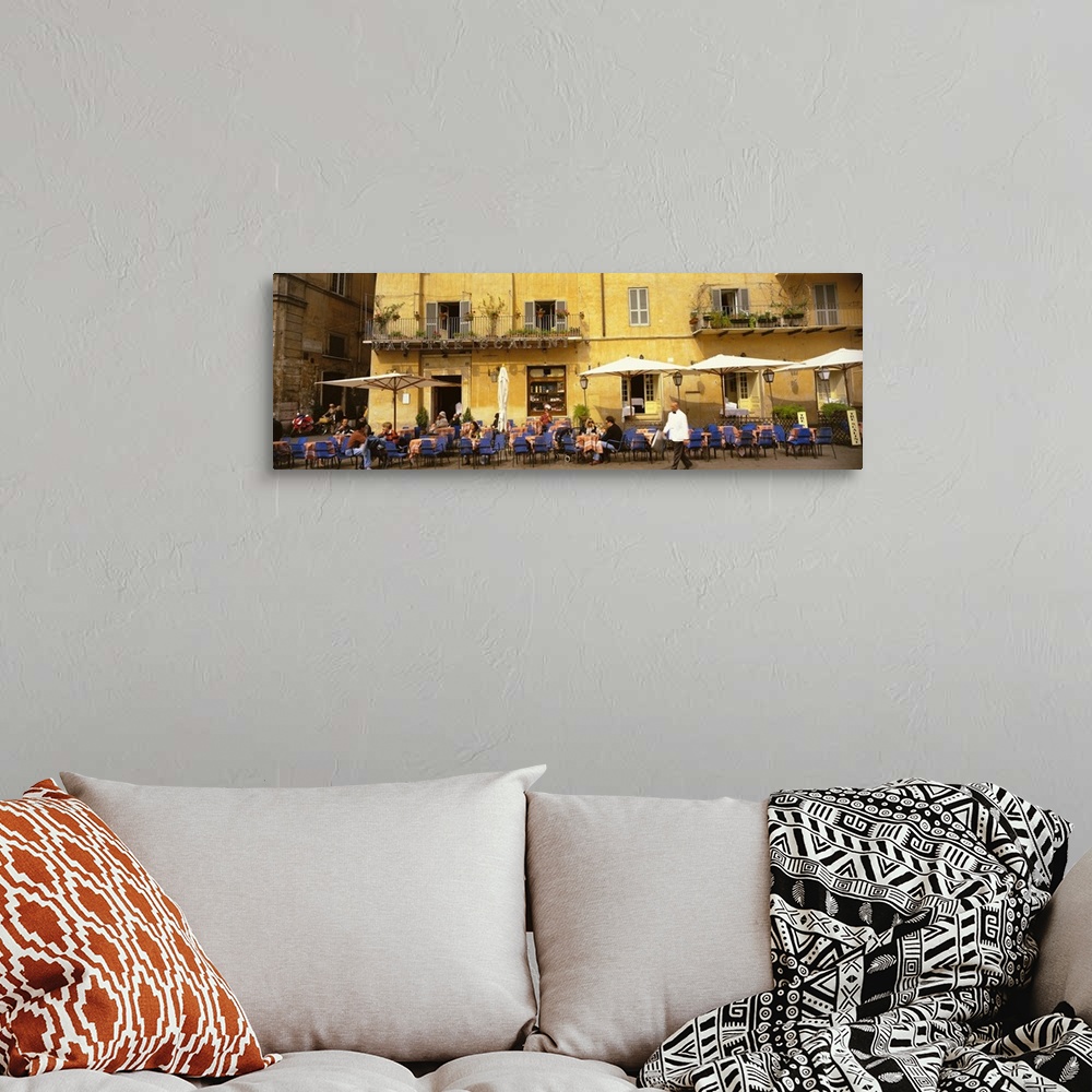 A bohemian room featuring Panoramic photo on canvas of people dining in an outside cafo area in Italy with old buildings in...