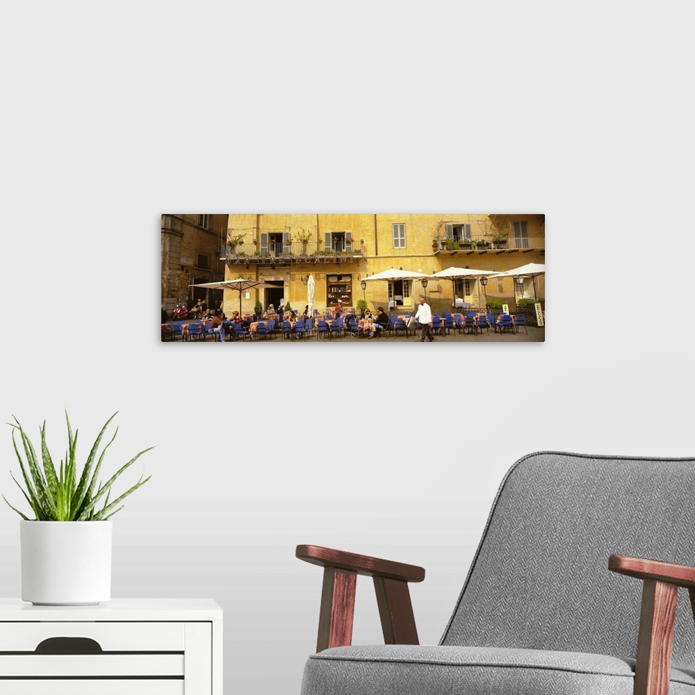 A modern room featuring Panoramic photo on canvas of people dining in an outside cafo area in Italy with old buildings in...