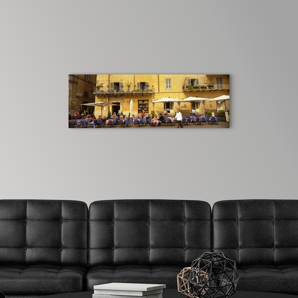 A modern room featuring Panoramic photo on canvas of people dining in an outside cafo area in Italy with old buildings in...