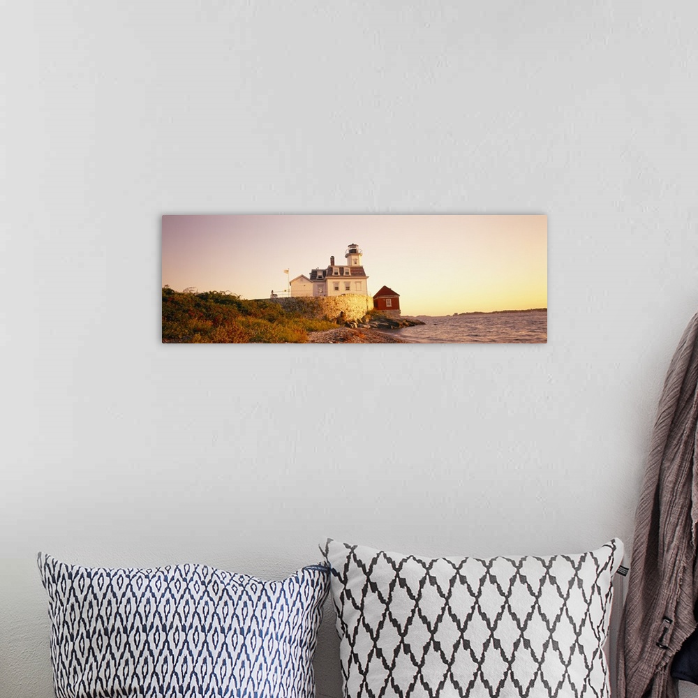 A bohemian room featuring Panoramic photograph on a big canvas of the Rose Island lighthouse overlooking the water at sunse...