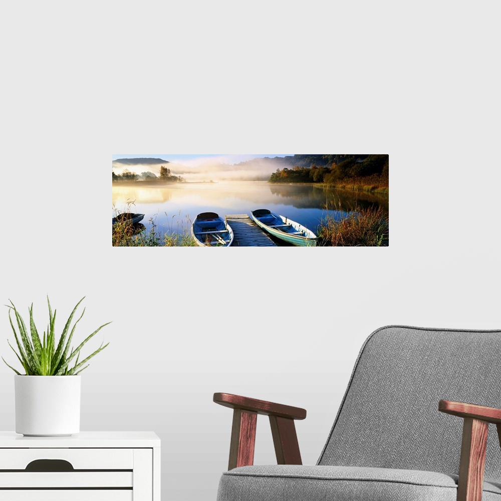 A modern room featuring Panoramic photograph showcases rowboats sitting next to a dock on a lake in Grasmere within Cumbr...
