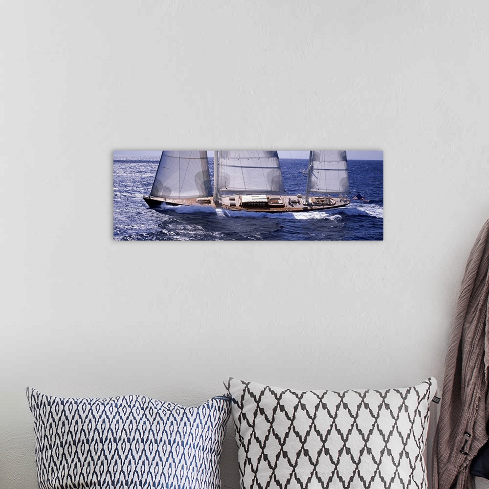A bohemian room featuring Large, horizontal photograph of a sailboat, slightly tilting as it charges through the blue water...