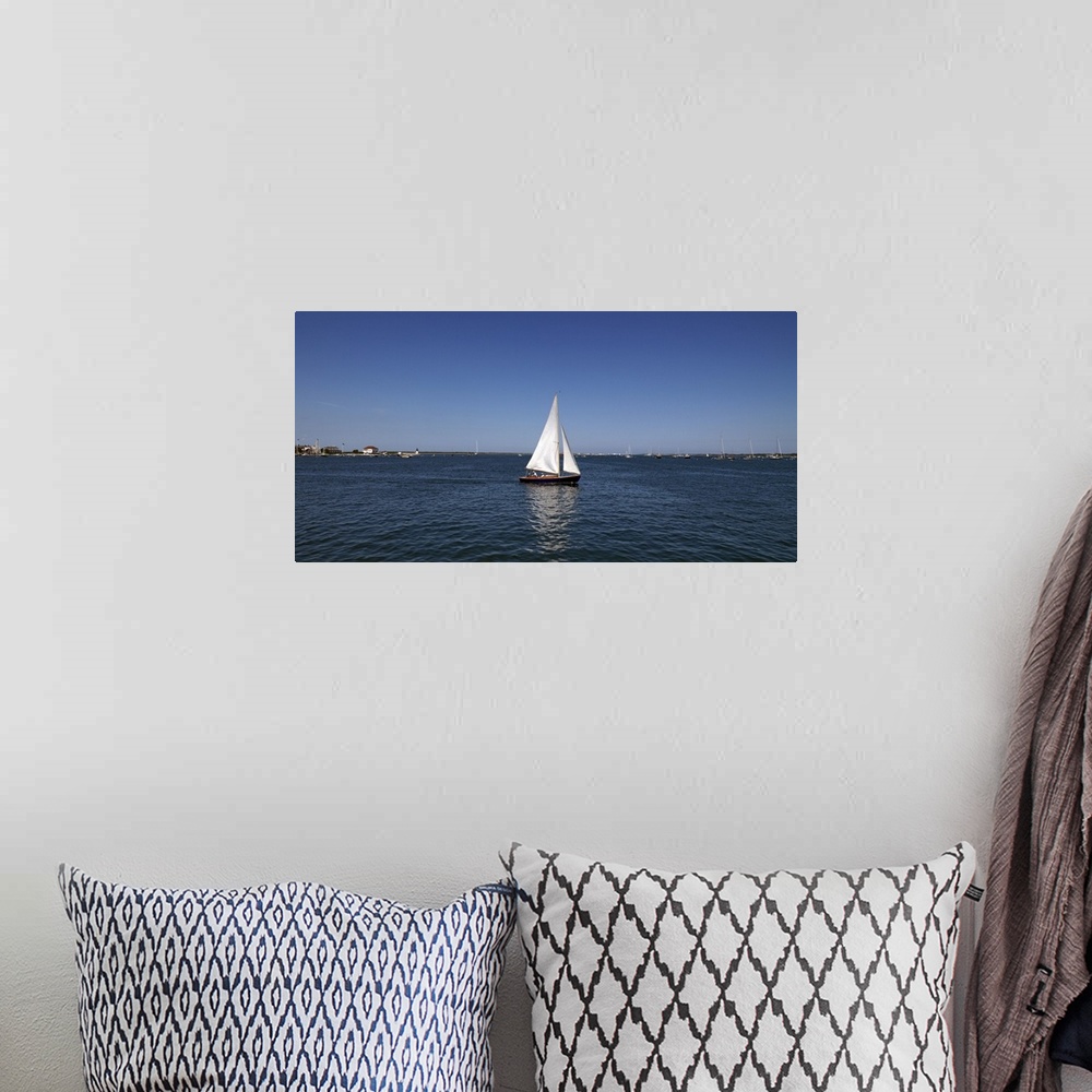 A bohemian room featuring Panoramic photograph of ship in the sea with marina in the distance under a clear sky.