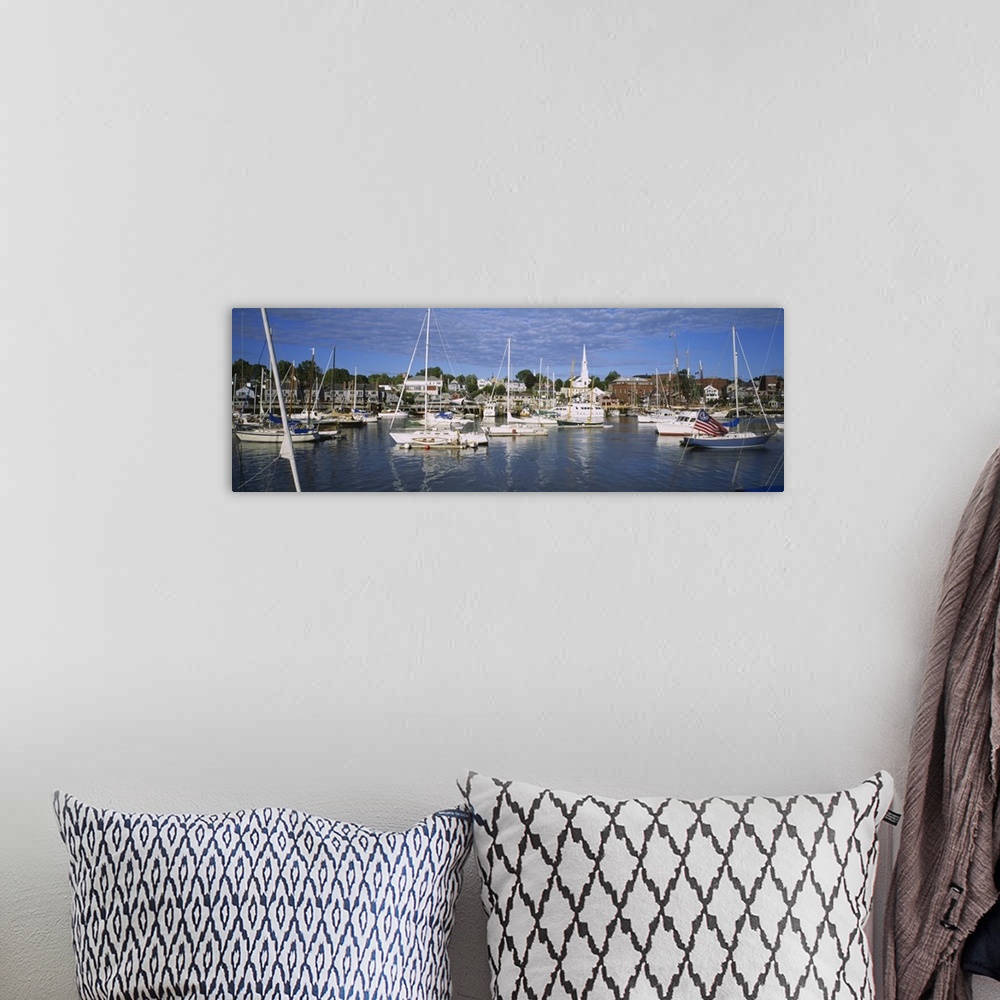 A bohemian room featuring This is a panoramic photograph of a harbor in New England filled with sail boats and a small vill...