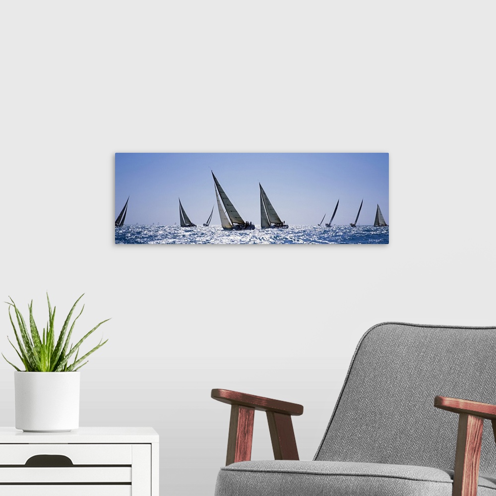 A modern room featuring This is a panoramic photograph taken at eye level of multiple boats on the water on a clear day.