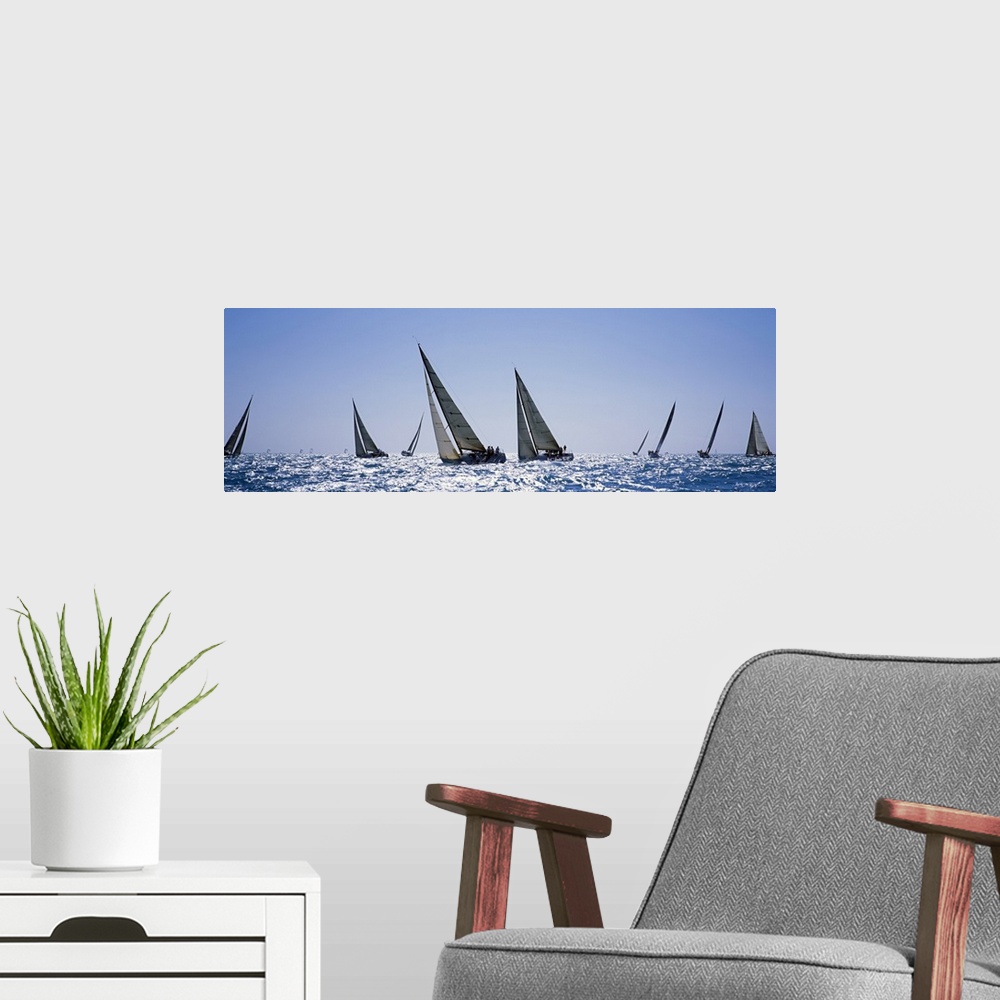 A modern room featuring This is a panoramic photograph taken at eye level of multiple boats on the water on a clear day.