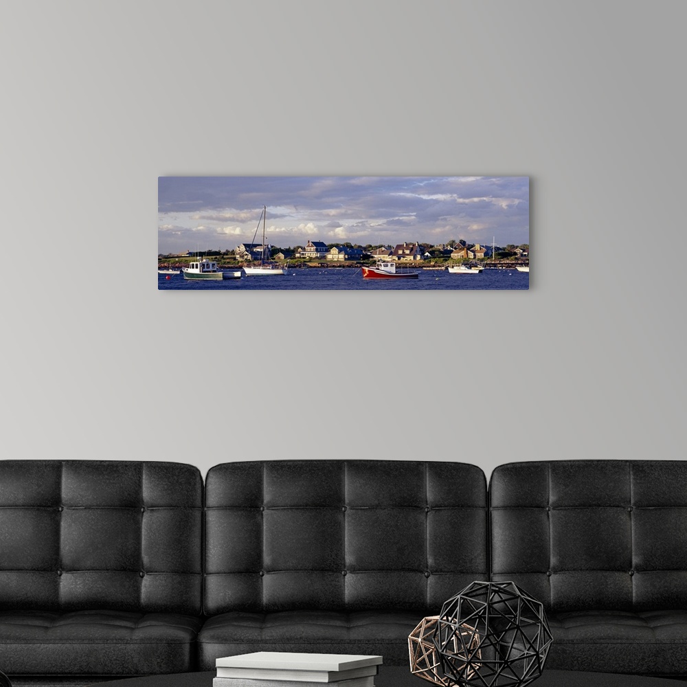A modern room featuring Large landscape photograph of many boast in Sakonnet Harbor, houses line the landscape, beneath a...