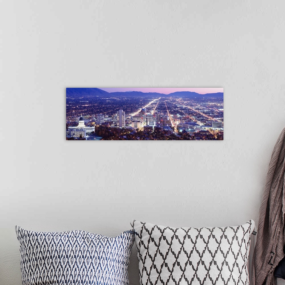 A bohemian room featuring Panoramic aerial photograph of city lit up at  night with mountain silhouettes in the distance.