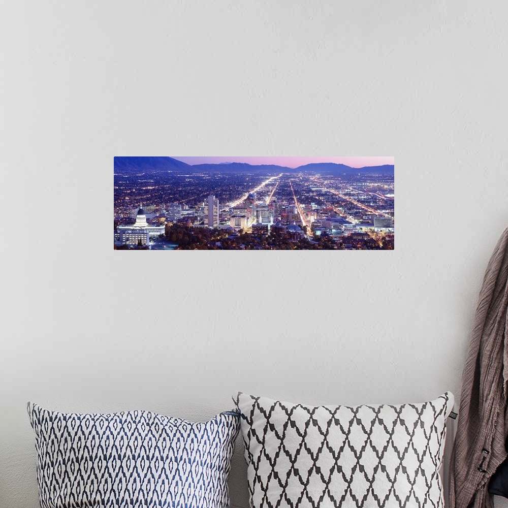 A bohemian room featuring Panoramic aerial photograph of city lit up at  night with mountain silhouettes in the distance.