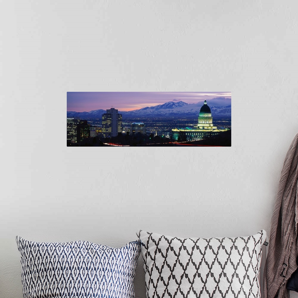 A bohemian room featuring Panoramic Rocky Mountains and downtown Salt Lake City, Utah as the last of the sun dips below the...