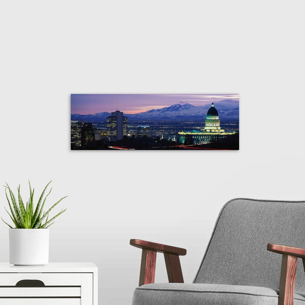 A modern room featuring Panoramic Rocky Mountains and downtown Salt Lake City, Utah as the last of the sun dips below the...
