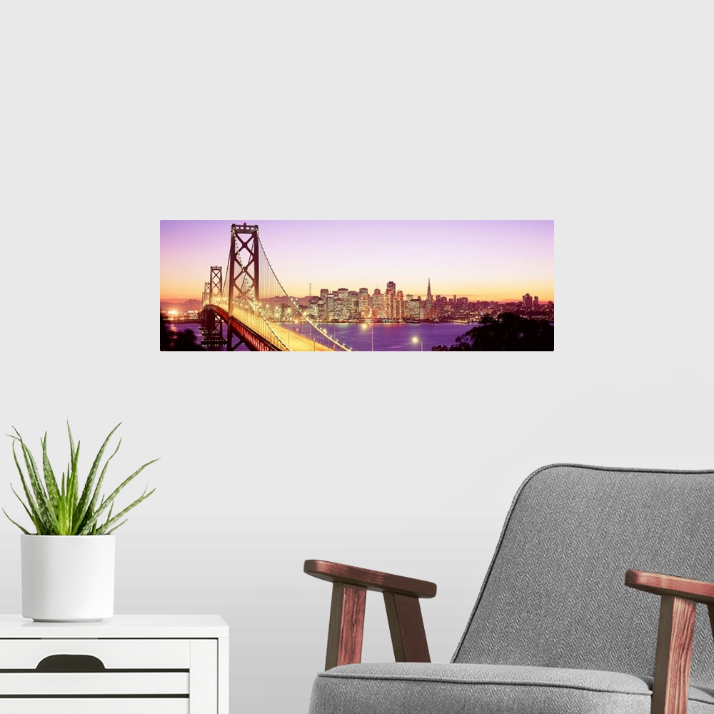 A modern room featuring An aerial photograph on panoramic wall art showing the Golden Gate Bridge and the city skyline in...