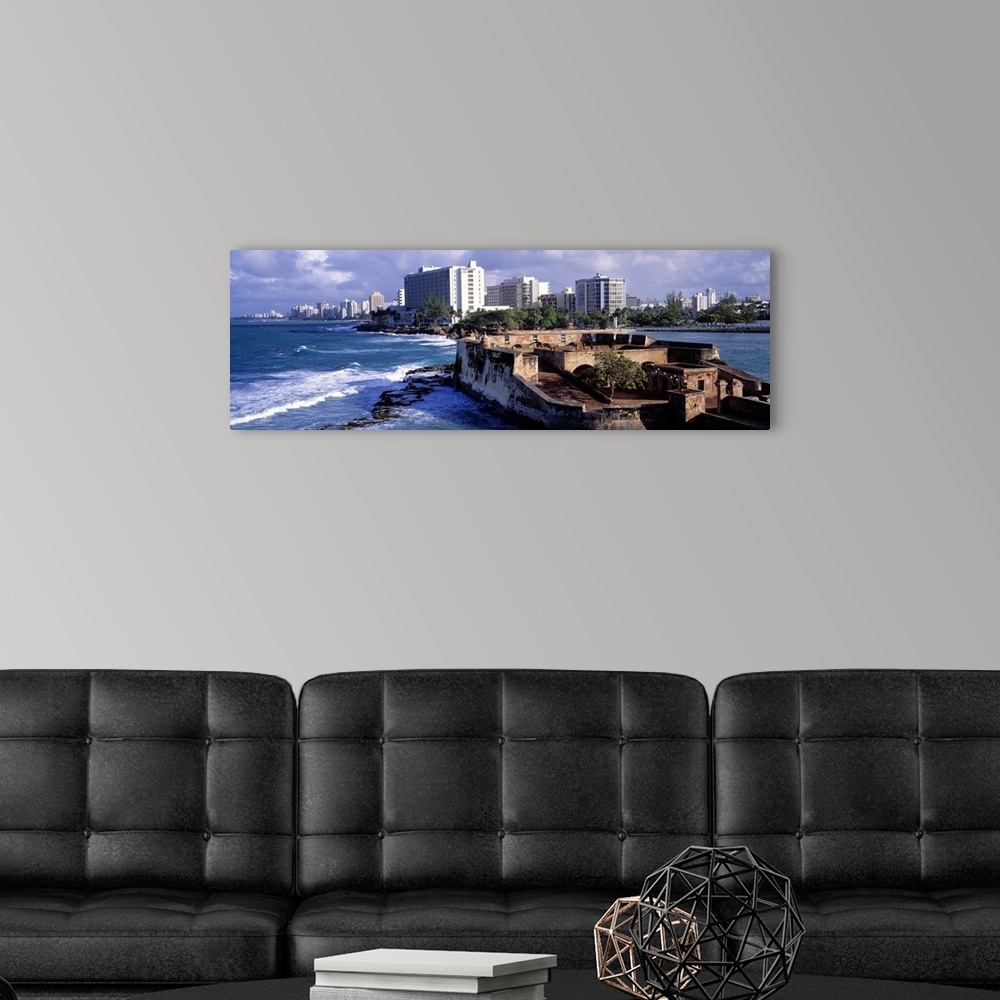 A modern room featuring Panoramic photograph of San Jeronimo Fort on the waters of San Juan, the city skyline in the back...
