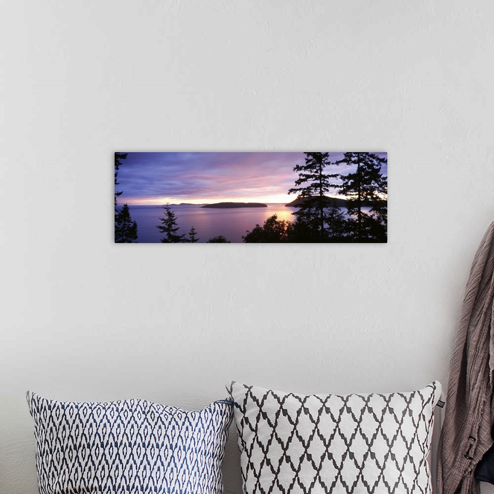 A bohemian room featuring The sunsets below on the ocean in this landscape photograph of small isles off the coast of Washi...