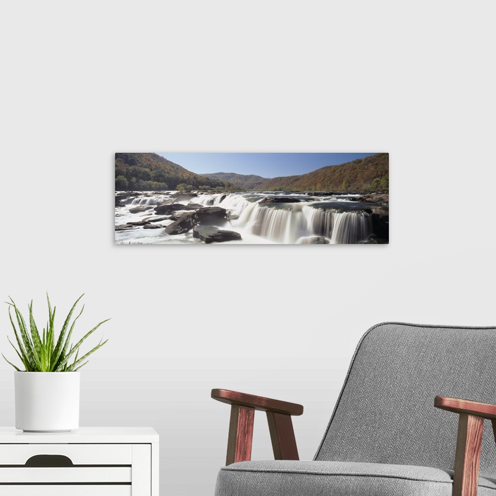 A modern room featuring Panoramic image on canvas of long waterfalls with rolling mountains of fall foliage in the backgr...