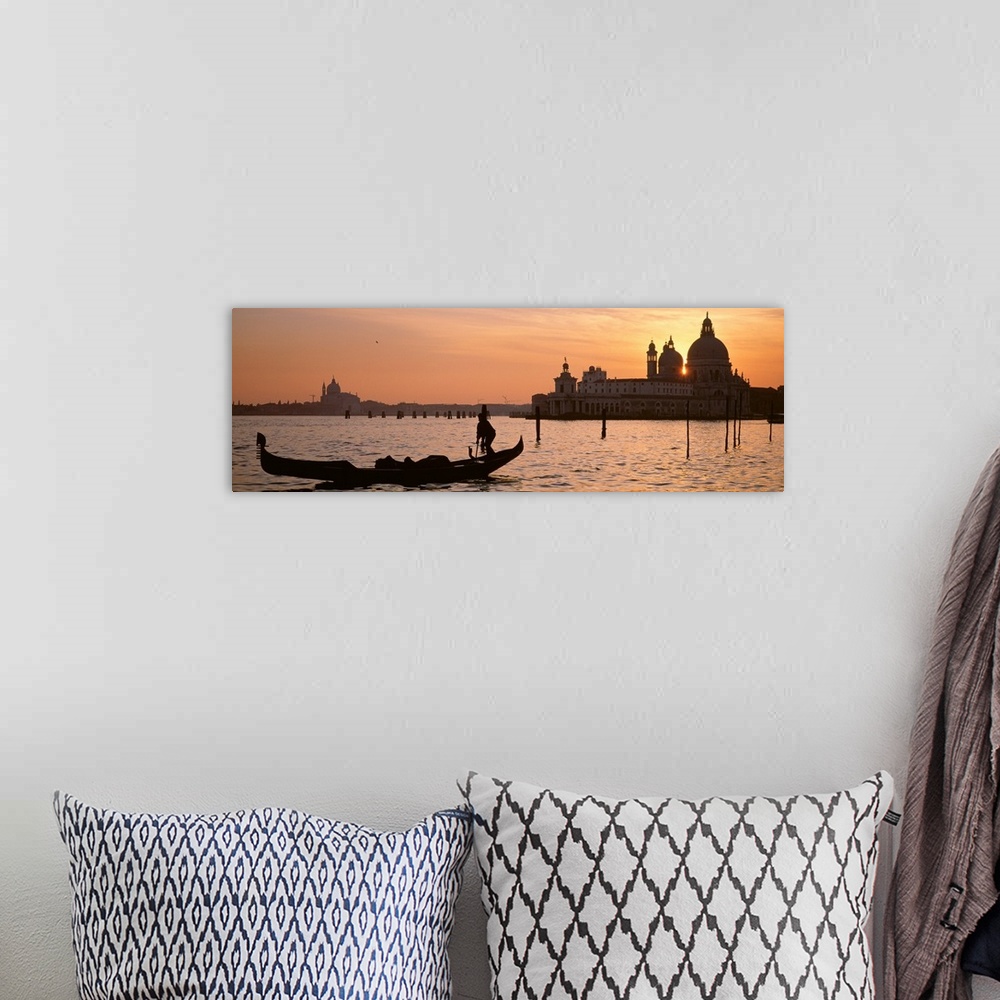 A bohemian room featuring Panoramic photograph of gondola on waterway with cityscape in background at sunset.