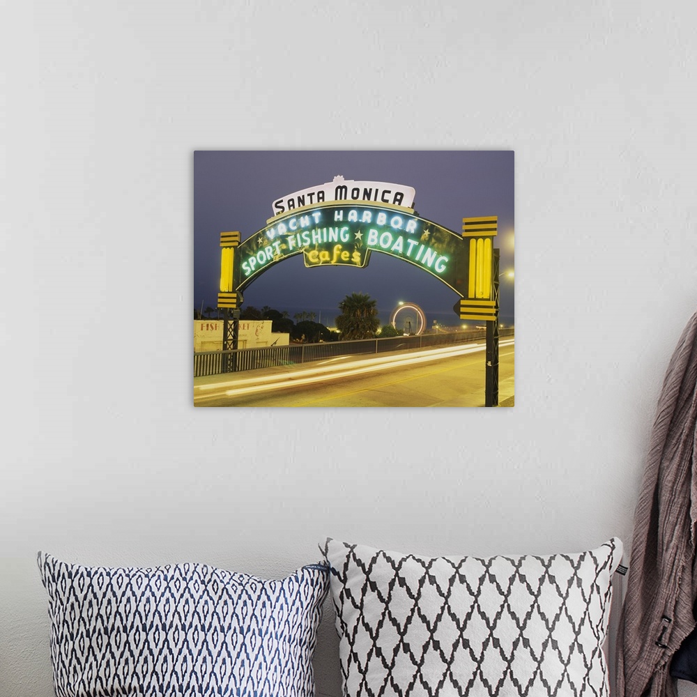 A bohemian room featuring Long exposure shot of a lit up Santa Monica Pier sign at night as traffic headlights go by and th...