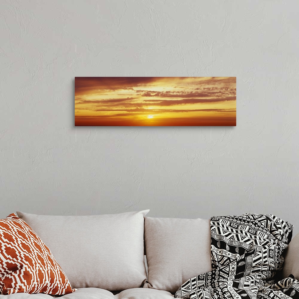 A bohemian room featuring Panoramic photo on canvas of a brightly colored sunset with horizontal clouds.