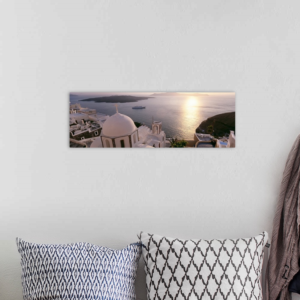 A bohemian room featuring Giant, high angle photograph of the tops of buildings, looking out onto the water in Santorini, G...