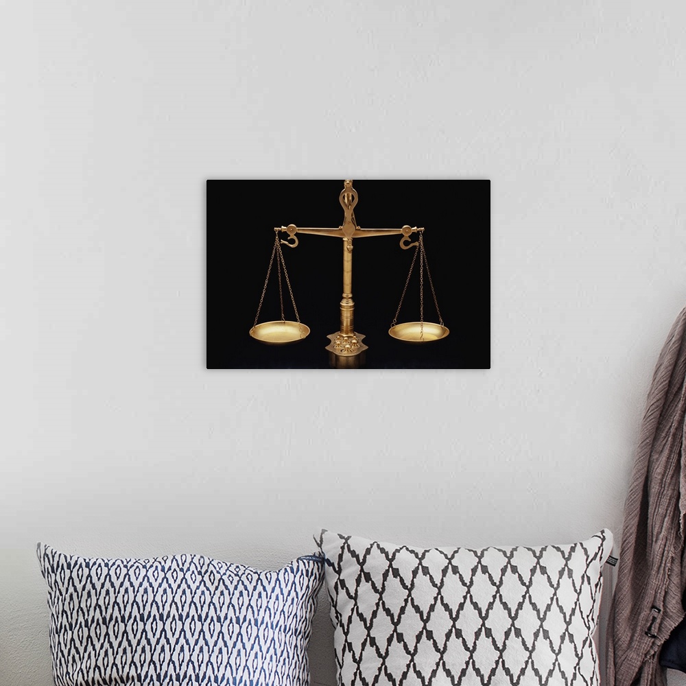 A bohemian room featuring Photograph taken of gold scales of justice against a black background.