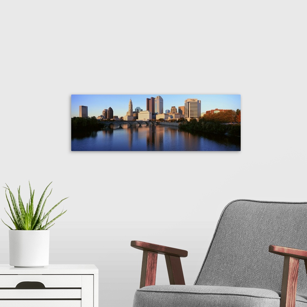 A modern room featuring Scioto River and Columbus Ohio skyline, with setting sunlight