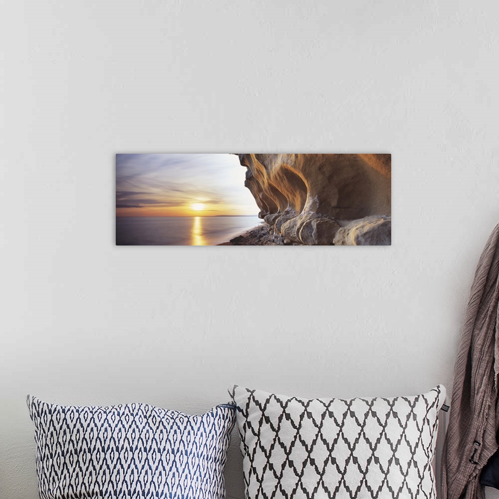 A bohemian room featuring Eroded rocks by the sea in this panoramic photograph; this is landscape wall art for the office o...