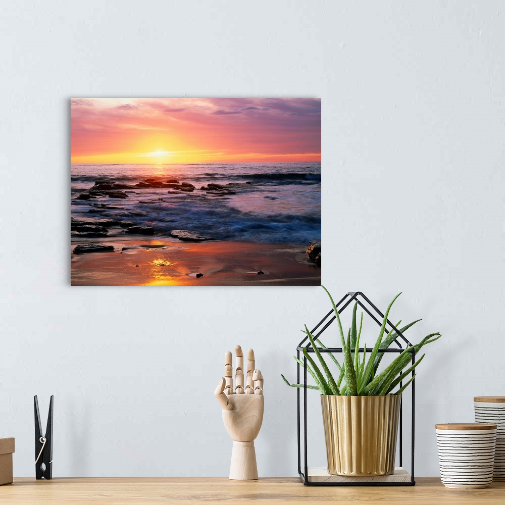 A bohemian room featuring Photograph of rocky shoreline at sunset with a cloudy sky.