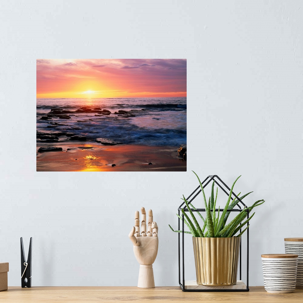 A bohemian room featuring Photograph of rocky shoreline at sunset with a cloudy sky.