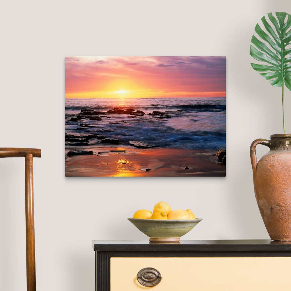 A traditional room featuring Photograph of rocky shoreline at sunset with a cloudy sky.