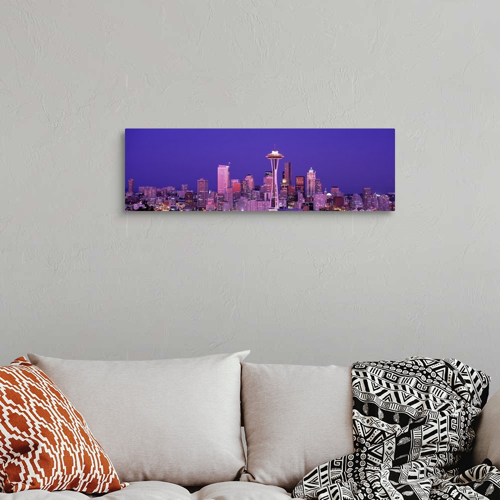 A bohemian room featuring The Seattle skyline is illuminated under a dusk sky and photographed as a panorama.