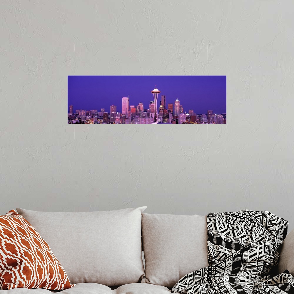 A bohemian room featuring The Seattle skyline is illuminated under a dusk sky and photographed as a panorama.