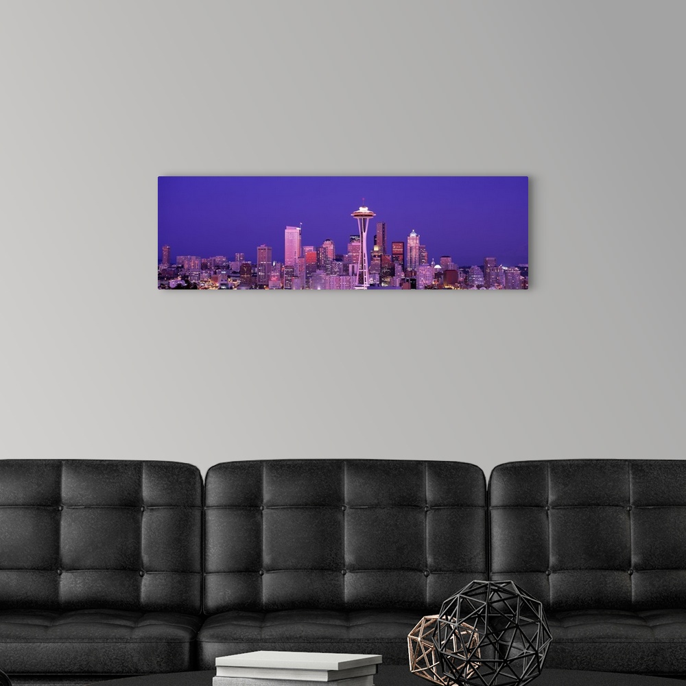 A modern room featuring The Seattle skyline is illuminated under a dusk sky and photographed as a panorama.