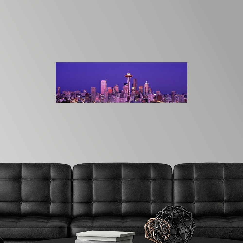 A modern room featuring The Seattle skyline is illuminated under a dusk sky and photographed as a panorama.