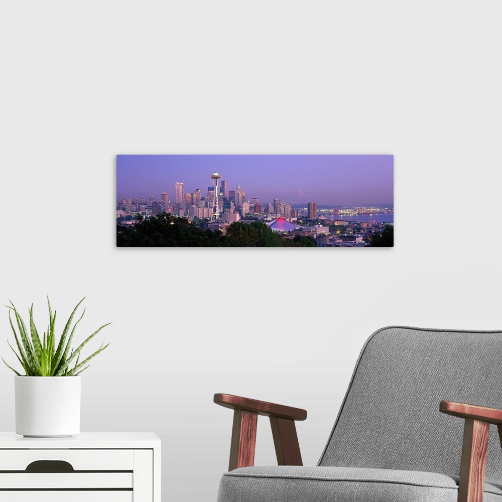 A modern room featuring Panoramic view of the Seattle, Washington skyline in the early evening, with the Space needle cle...