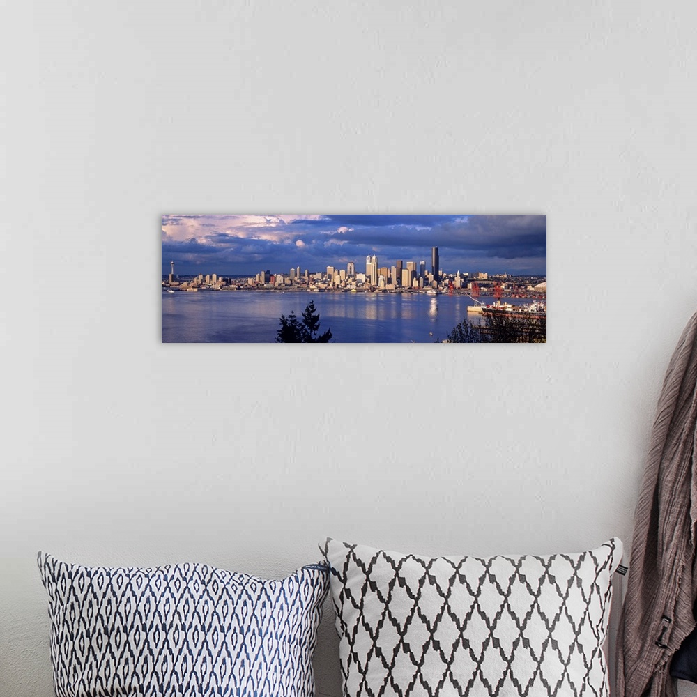 A bohemian room featuring Panoramic, distant photograph over the water of the Seattle skyline, beneath a sky full of large,...