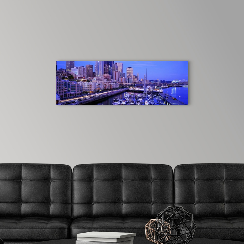 A modern room featuring Landscape photograph along the coast of the Seattle skyline at dusk, with many boats docked in th...