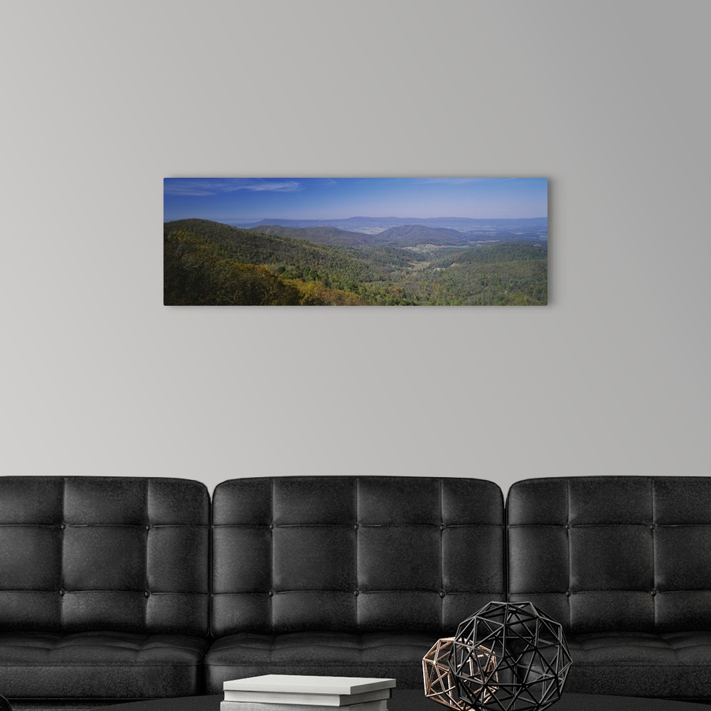 A modern room featuring Panoramic view of the sprawling forest over the hilly landscape of Virginia on a clear, sunny day.