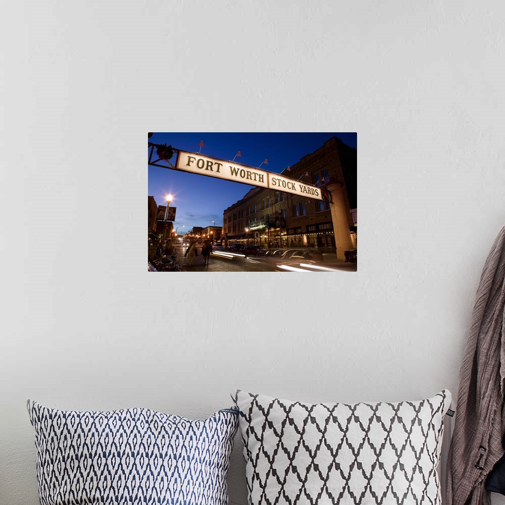 A bohemian room featuring Landscape photograph of the Fort Worth Stock Yards sign over a road lined with buildings, at dusk...