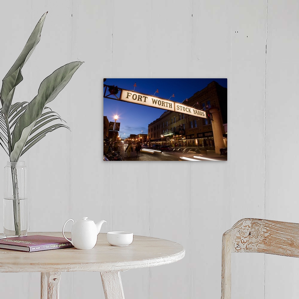 A farmhouse room featuring Landscape photograph of the Fort Worth Stock Yards sign over a road lined with buildings, at dusk...