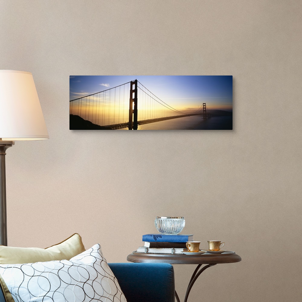 A traditional room featuring Panoramic, angled photograph of the Golden Gate Bridge, silhouetted as the sun rises in the sky o...