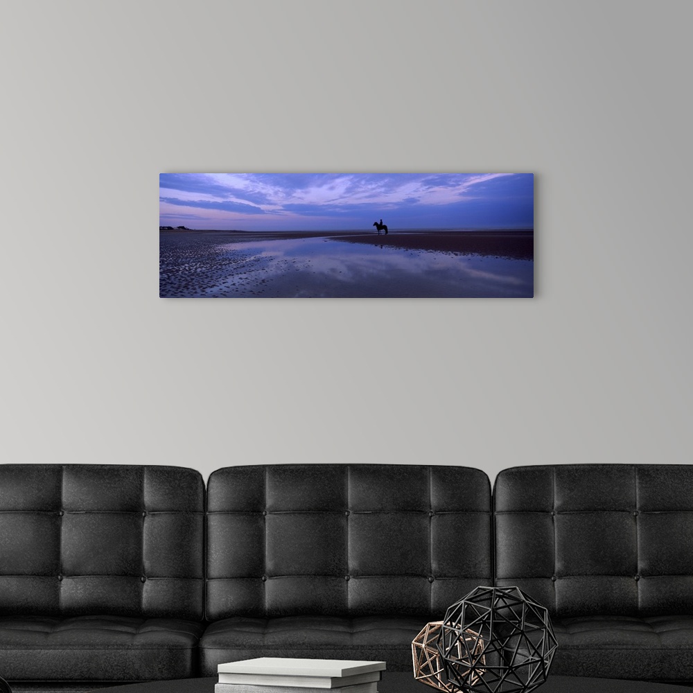 A modern room featuring Silhouette of a horse with rider on the beach at dawn Camber Sands Camber East Sussex England