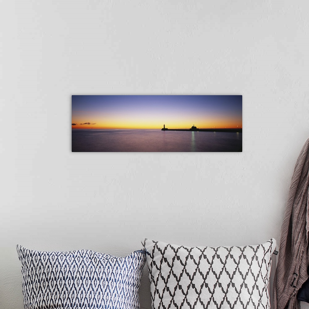 A bohemian room featuring Panoramic photo on canvas of a lighthouse and pier silhouetted against a sunset.