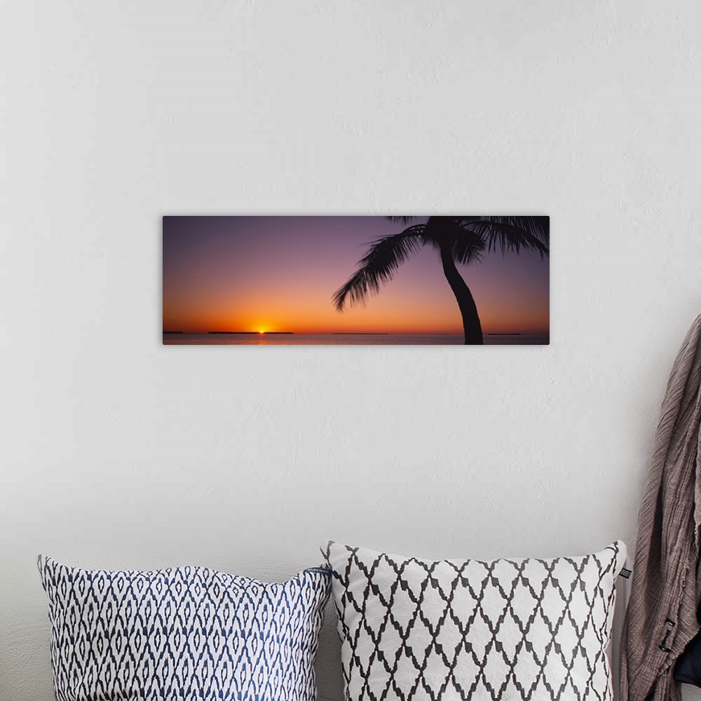 A bohemian room featuring The last bit of sun is peaking over the horizon illumniating the sky in brilliant oranges and pur...