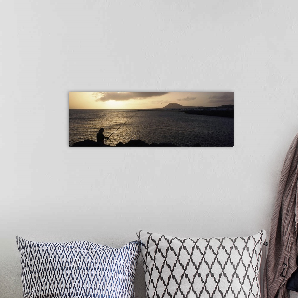 A bohemian room featuring Silhouette of a person fishing in the sea, La Graciosa Island, Canary Islands, Spain