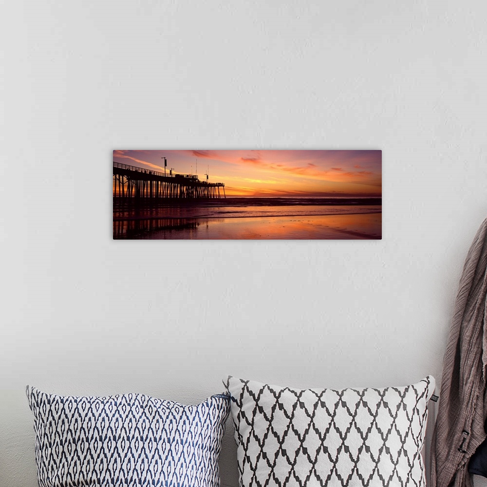 A bohemian room featuring Sunset at the shore with feathery clouds in the sky and board walk over the ocean.